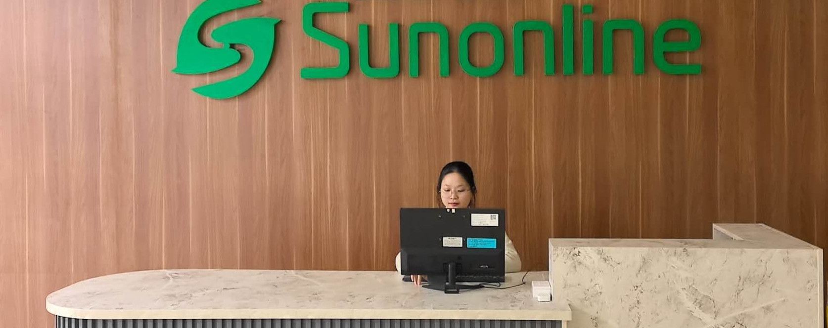 SUNONLINE reception with the company logo wall